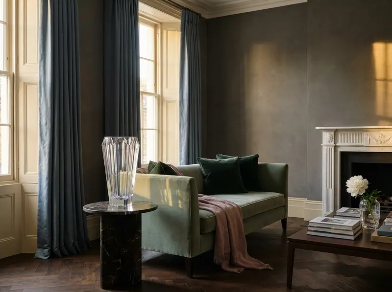 Ultra-luxury European atelier living room with prominent Lalique crystal vase, sage velvet chaise, slate blue silk curtains and warm charcoal limewashed walls — Quiet Luxury Neuroscience by Beverly Hills Luxury Interiors